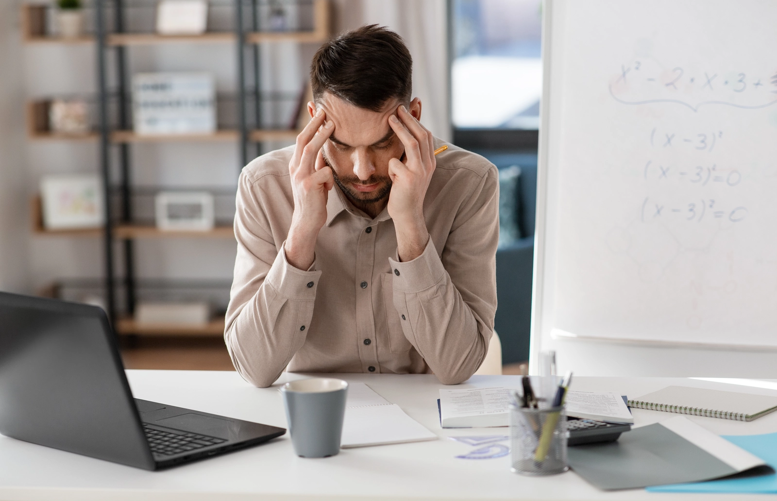 an anxious man sits at his work desk